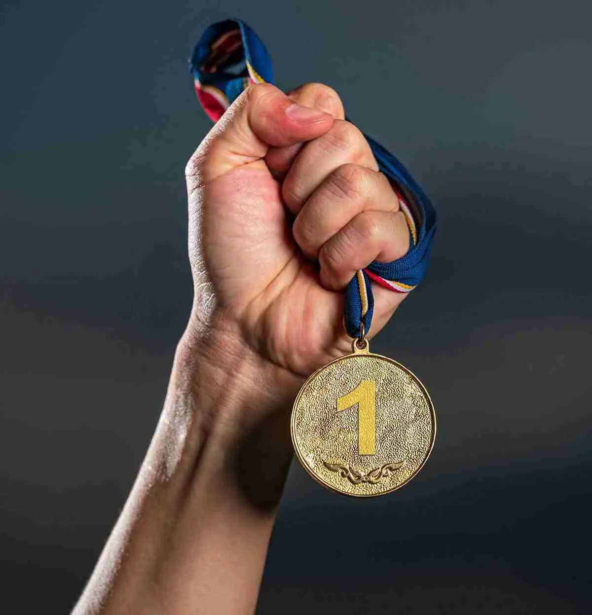 Hand holding a medal for 1st place.