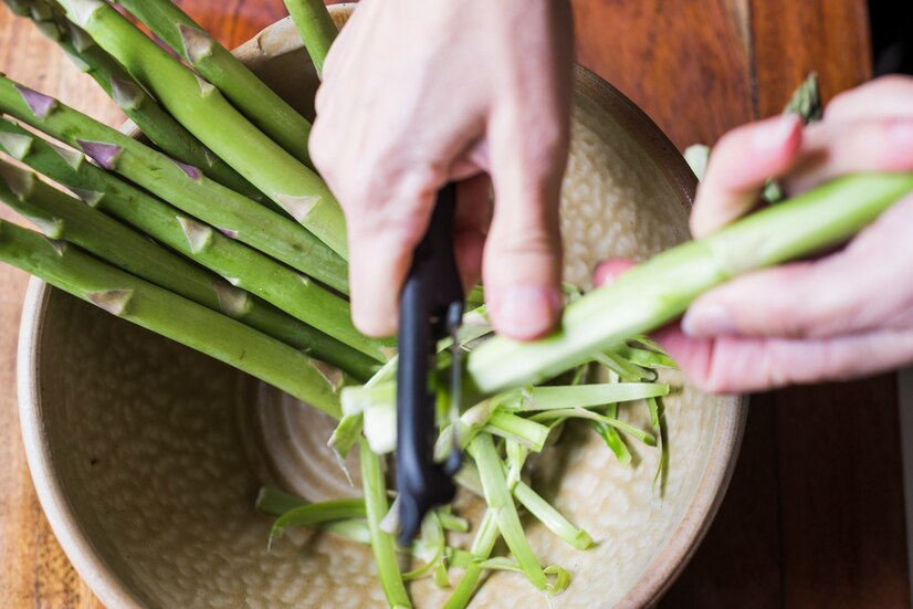 crop-person-cleaning-asparagus_23-2147779205