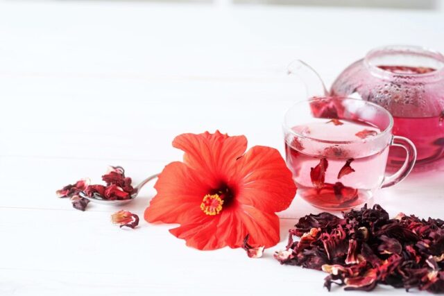 cup-healthy-gibiskus-red-tea-with-gibiskus-flower-white-wooden-table_