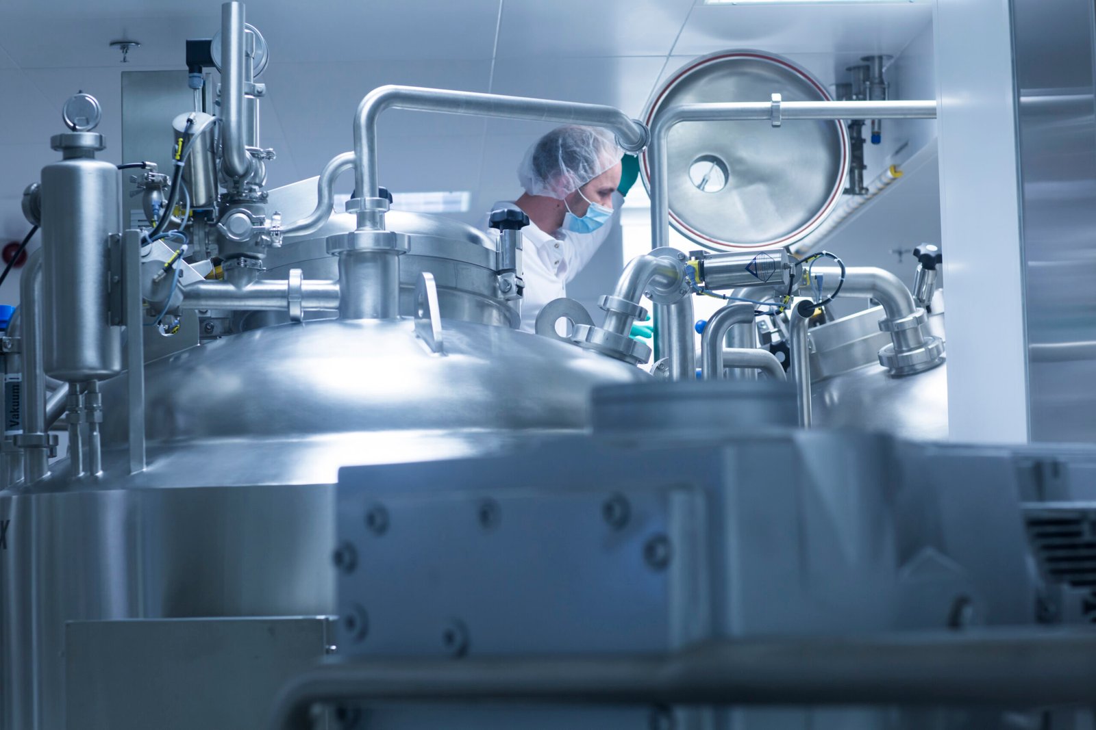 Worker operating pharmaceutical production equipment in pharmaceutical plant
